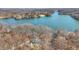 Expansive aerial shot displaying a waterfront residence with serene lake and wooded surroundings at 7899 S Timber Cliff Ln, Trafalgar, IN 46181