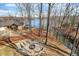 Aerial view of lake house featuring a fire pit area with seating, waterfront access, and beautiful wooded views at 7899 S Timber Cliff Ln, Trafalgar, IN 46181