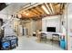 A basement featuring a water heater, exposed ceiling, and a workspace with a computer and chairs at 7899 S Timber Cliff Ln, Trafalgar, IN 46181