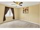 Comfortable bedroom featuring tan walls, plush carpeting, and natural light from a window at 7899 S Timber Cliff Ln, Trafalgar, IN 46181