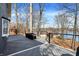 Expansive deck with a modern railing and scenic lake views beyond the trees at 7899 S Timber Cliff Ln, Trafalgar, IN 46181