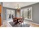 Cozy dining room with warm wood table, chandelier, and scenic outdoor views through large windows and glass doors at 7899 S Timber Cliff Ln, Trafalgar, IN 46181
