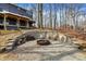 Outdoor fire pit with chairs and surrounding stone wall, providing a cozy space for relaxing and entertaining at 7899 S Timber Cliff Ln, Trafalgar, IN 46181