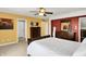 Bright main bedroom featuring red accent wall, a ceiling fan, and two dressers at 7899 S Timber Cliff Ln, Trafalgar, IN 46181