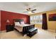 Bright main bedroom with red accent wall, a ceiling fan, and large windows at 7899 S Timber Cliff Ln, Trafalgar, IN 46181