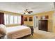 Spacious main bedroom with red accent wall, a ceiling fan, and large windows at 7899 S Timber Cliff Ln, Trafalgar, IN 46181