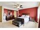 Large main bedroom with red accent wall, a ceiling fan, and plenty of storage at 7899 S Timber Cliff Ln, Trafalgar, IN 46181