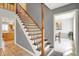 Open staircase with wooden railing and ceramic tile flooring leading to the second floor at 7899 S Timber Cliff Ln, Trafalgar, IN 46181