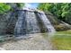 Natural waterfall flowing over a rocky cliff into a clear stream in a green forest at 7899 S Timber Cliff Ln, Trafalgar, IN 46181