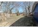 Back yard features a wood fence, shed, firepit, and covered patio, plus mature trees at 8026 Roy Rd, Indianapolis, IN 46219