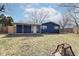 Exterior view of blue home with covered patio and view of fenced back yard at 8026 Roy Rd, Indianapolis, IN 46219