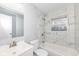 Bathroom features marble tile walls, updated vanity, a toilet, and tub under a window at 8026 Roy Rd, Indianapolis, IN 46219