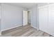 Bright bedroom features wood-look floors, light gray walls, closet, and an open doorway at 8026 Roy Rd, Indianapolis, IN 46219