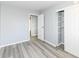 Bright bedroom featuring wood-look floors, light gray walls, a closet, and an open doorway at 8026 Roy Rd, Indianapolis, IN 46219