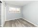 Clean bedroom featuring wood-look floors, light gray walls, and a window at 8026 Roy Rd, Indianapolis, IN 46219