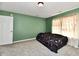 Bedroom features green walls, neutral carpet, and a window with patterned curtains at 8630 Aylesworth Dr, Camby, IN 46113