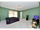 A green bedroom with neutral carpet, a black cabinet, and a fish tank on a stand at 8630 Aylesworth Dr, Camby, IN 46113