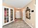 Inviting foyer with durable flooring, decorative mirror, and French doors to adjacent room at 8630 Aylesworth Dr, Camby, IN 46113