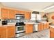 Updated kitchen boasting stainless steel appliances, wood cabinetry, white countertops and grey backsplash at 8630 Aylesworth Dr, Camby, IN 46113