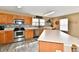 Light-filled kitchen equipped with stainless steel appliances, wood cabinets, and a spacious kitchen island at 8630 Aylesworth Dr, Camby, IN 46113