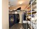 Functional laundry area features shelving, front loading washer and dryer set, and neutral paint at 8630 Aylesworth Dr, Camby, IN 46113