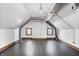 Attic featuring finished hardwood floors and two small windows for natural light at 914 Chase St, Anderson, IN 46016