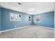 Bedroom featuring calming blue walls, plush gray carpeting, and bright windows at 914 Chase St, Anderson, IN 46016