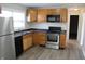 Functional kitchen featuring stainless steel appliances, plentiful wood cabinets and modern black countertops at 9238 Celtic Ct, Indianapolis, IN 46235