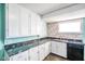 A sunlit kitchen with ample storage in the white cabinets and black countertops at 93 Walnut St, Indianapolis, IN 46227