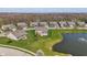 A bird's-eye view shows a house nestled in a community with a pond and lush greenery, highlighting the serene setting at 9559 Summer Hollow Dr, Fishers, IN 46037