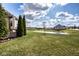 Expansive backyard with lush green grass, pond view, and mature trees, offering serene outdoor living at 9559 Summer Hollow Dr, Fishers, IN 46037
