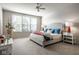 Cozy bedroom with large window, ceiling fan, carpeted floor, bed with soft pillows and decorative lamps at 9559 Summer Hollow Dr, Fishers, IN 46037