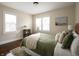 Comfortable bedroom with wood floors, a green quilt bedspread, and bright windows at 1014 Shannon Ave, Indianapolis, IN 46201