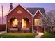 Charming brick home with arched porch, manicured lawn, and flowering tree at twilight at 1014 Shannon Ave, Indianapolis, IN 46201