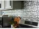 Close-up of a modern kitchen backsplash with stainless steel appliances, and granite countertops at 1014 Shannon Ave, Indianapolis, IN 46201