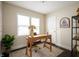 Bright office space with a wooden desk, gold desk lamp, and a large window at 1014 Shannon Ave, Indianapolis, IN 46201