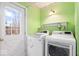 Bright laundry room with modern washer and dryer, utility sink, shelf and a view to the backyard at 10333 E 211Th St, Noblesville, IN 46062