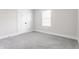 Bright bedroom showcasing neutral walls, carpet, a window, and a white door at 1533 Harlan St, Indianapolis, IN 46203
