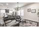 Open-concept living room with leather sofas, chandelier, and view into modern kitchen at 1533 Harlan St, Indianapolis, IN 46203