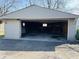 Spacious garage with open overhead door and gravel driveway at 1607 Elmhurst Dr, Indianapolis, IN 46219