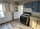 Kitchen with appliances, wood-look vinyl flooring, and a pass-through window at 1632 W 17Th St, Anderson, IN 46016