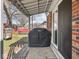 The covered back patio has a barbeque grill, and overlooks a backyard with mature trees at 1840 Hibiscus Dr, Indianapolis, IN 46219