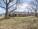 Home backyard shows brick exterior, mature trees, swing, and patio at 1840 Hibiscus Dr, Indianapolis, IN 46219
