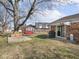 Spacious backyard with mature trees, a swing, a deck and a red outdoor shed at 1840 Hibiscus Dr, Indianapolis, IN 46219