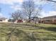 View of backyard with a rustic swing set, storage shed, and surrounding green space on a sunny day at 1840 Hibiscus Dr, Indianapolis, IN 46219
