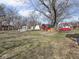 Wide backyard features grass, a wooden deck, shed, and a red backyard utility building at 1840 Hibiscus Dr, Indianapolis, IN 46219