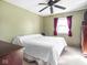 Bedroom featuring neutral carpet, a ceiling fan, and a window with dark red curtains at 1840 Hibiscus Dr, Indianapolis, IN 46219