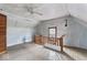 Attic room with wood floors, ceiling fan and natural wood railing overlooking the staircase at 2123 N F St, Elwood, IN 46036