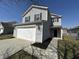 Charming two-story home with attached garage, black shutters and manicured landscaping at 2402 Middle View Dr, Columbus, IN 47201