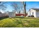 A backyard shed, firepit, and bench seating are all included in this big backyard at 3225 S Rybolt Ave, Indianapolis, IN 46221